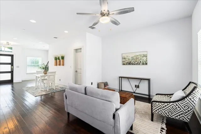 a living room with furniture a ceiling fan and a rug