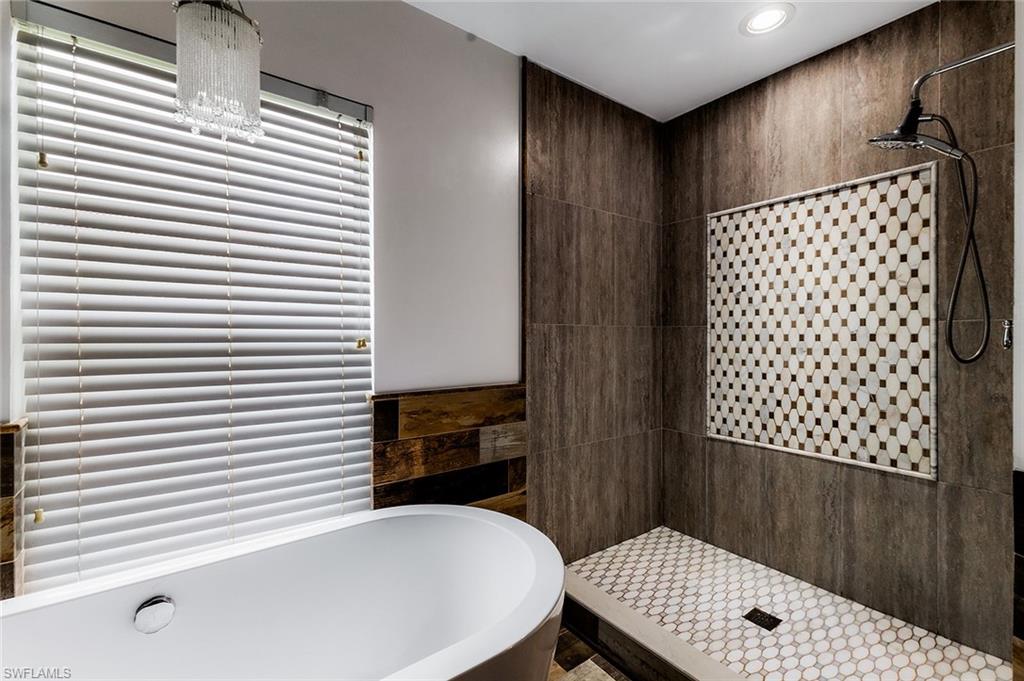 1064 Hampton Circle Naples, FL 34105 - Photo 19 of 32 a bathroom with a bathtub and a sink