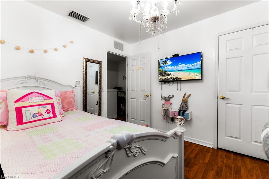 1064 Hampton Circle Naples, FL 34105 - Photo 21 of 32 a bedroom with a bed and a flat screen tv