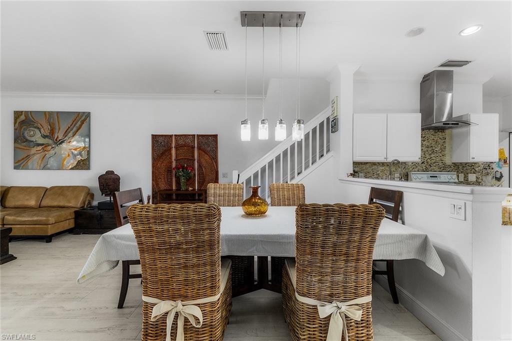 1064 Hampton Circle Naples, FL 34105 - Photo 9 of 32 a dining room with furniture and wooden floor