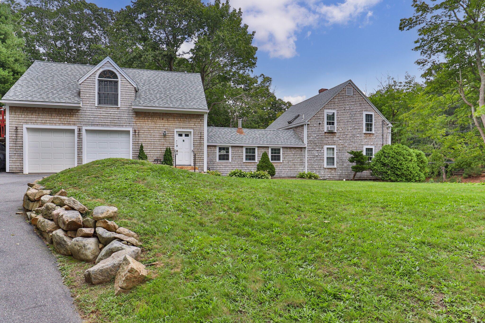 99 Main Street Sandwich, MA 02563 - Photo 1 of 43 a front view of a house with a yard and garage