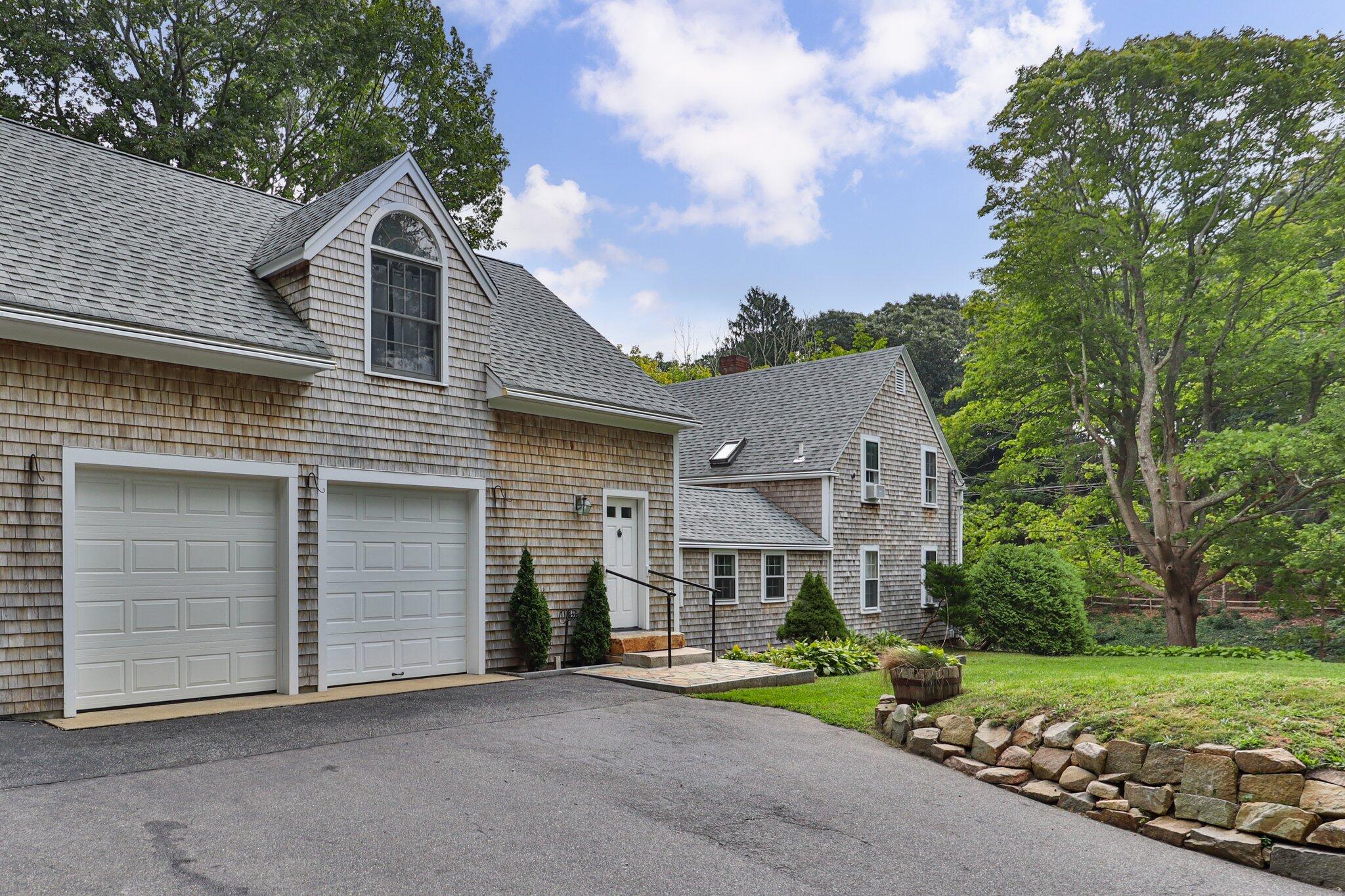 99 Main Street Sandwich, MA 02563 - Photo 2 of 43 a front view of a house with a yard and garage