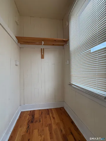 a view of a room with wooden floor and a window