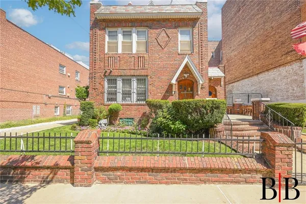 a front view of a house with a garden and plants