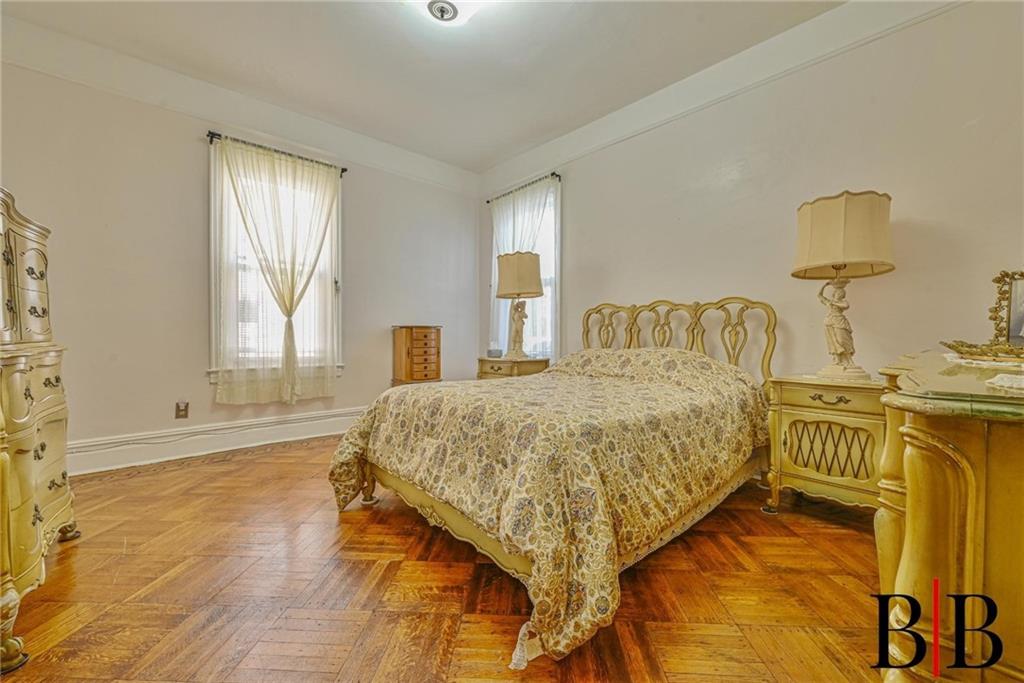 2219 83rd Street Brooklyn, NY 11214 - Photo 12 of 25 a bedroom with a bed and wooden floor