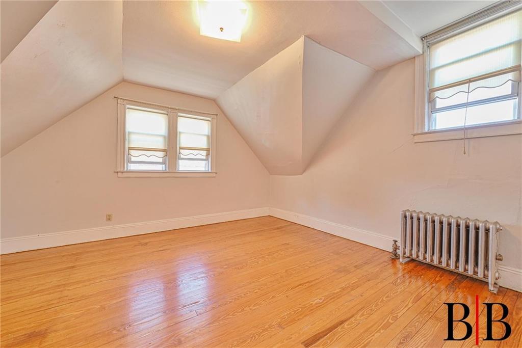 2219 83rd Street Brooklyn, NY 11214 - Photo 21 of 25 an empty room with wooden floor and windows
