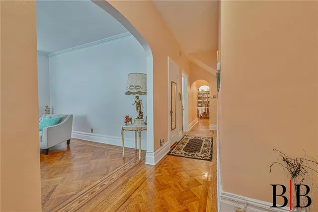 a view of a hallway with wooden floor and a living room