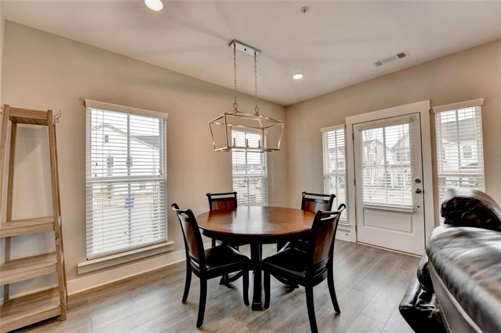1714 Prospect Way Conyers, GA 30094 - Photo 4 of 35 a dining room with furniture a chandelier and wooden floor