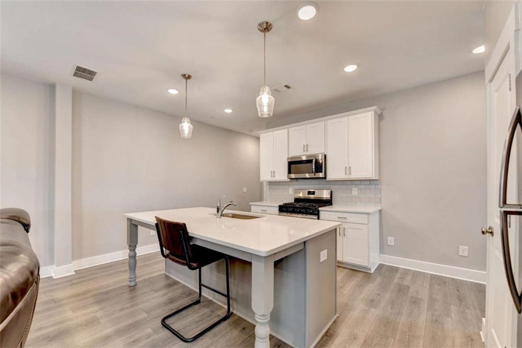 1714 Prospect Way Conyers, GA 30094 - Photo 9 of 35 a kitchen with kitchen island a wooden floor and white appliances