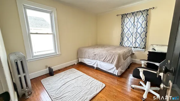 a bedroom with a bed and wooden floor