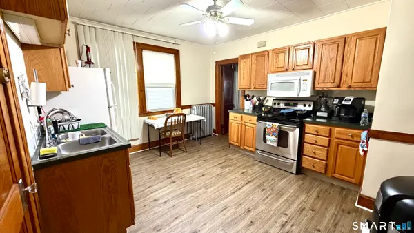 a kitchen with stainless steel appliances a stove sink and wooden floor