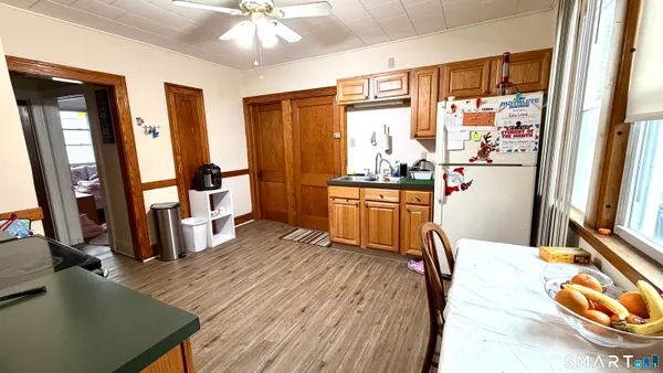 a kitchen with stainless steel appliances granite countertop a refrigerator a stove and a sink with wooden floor