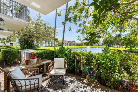 a view of a patio with couches table and chairs and potted plants