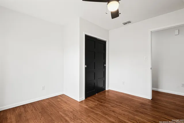 a view of an empty room with wooden floor