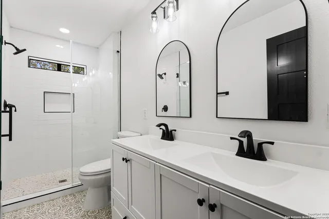 a bathroom with a sink a toilet and a mirror