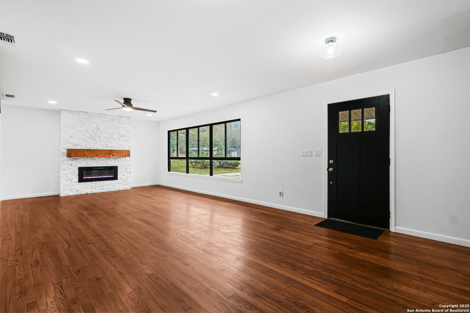 728 Rittiman Road San Antonio, TX 78209 - Photo 4 of 31 an empty room with wooden floor and windows