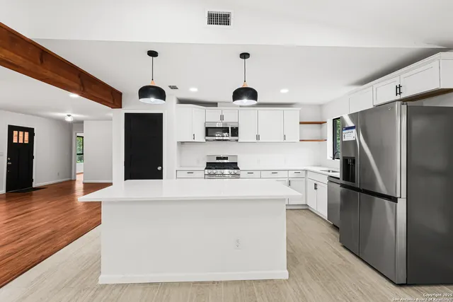 a kitchen with stainless steel appliances a refrigerator stove microwave and sink