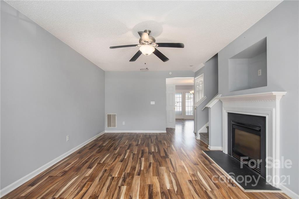 3228 Barons Court Road Charlotte, NC 28213 - Photo 3 of 19 a view of a livingroom with a fireplace a ceiling fan and wooden floor