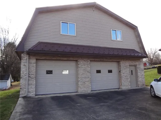 a front view of a house with a garden and yard
