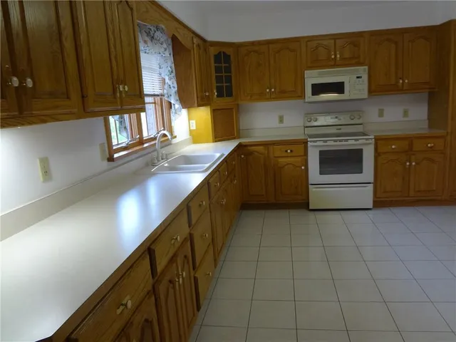a view of an empty room with furniture and a window
