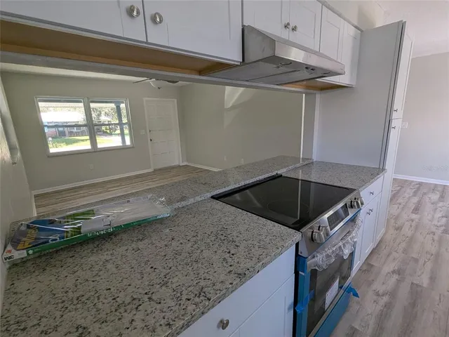 a kitchen with a sink a counter top space cabinets and stainless steel appliances