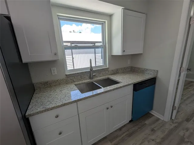 a view of a room with wooden floor and a window