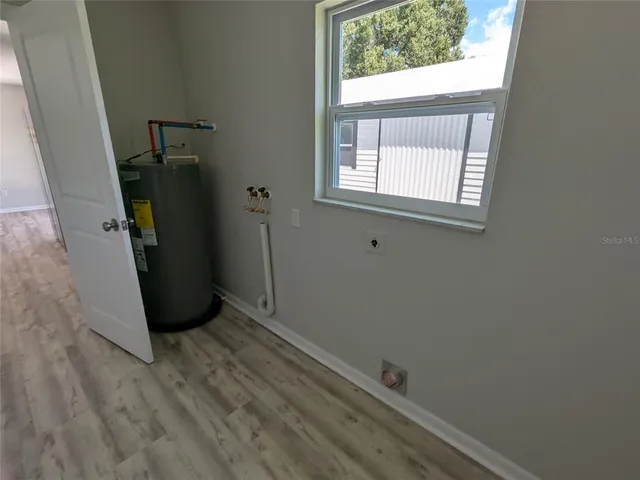 a view of a kitchen with wooden floor and a refrigerator