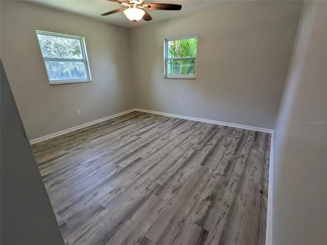 a view of an empty room with wooden floor