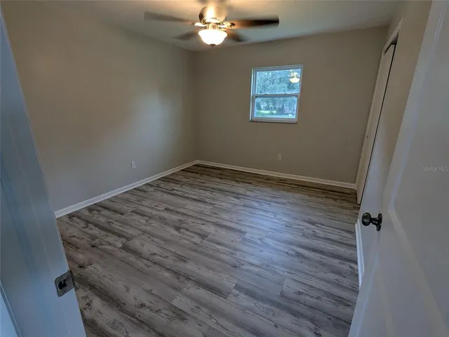 a view of a room with wooden floor and window