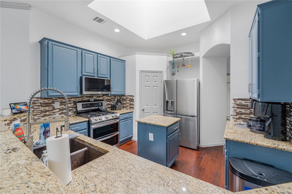 2813 Ridgemere Drive Flower Mound, TX 75028 - Photo 4 of 18 a kitchen with stainless steel appliances granite countertop a sink stove and refrigerator
