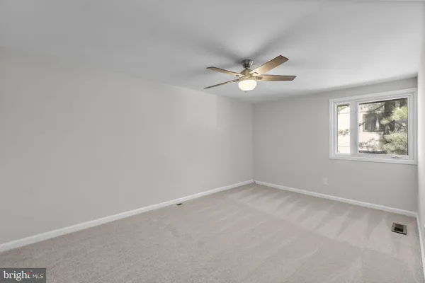 an empty room with a window and a ceiling fan
