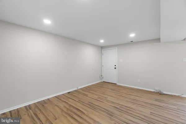 a view of room with wooden floor and white walls
