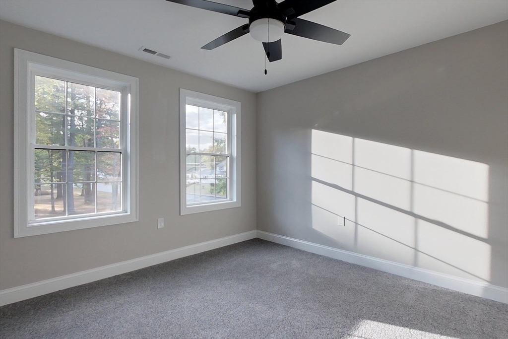 129 Lowell Road Pepperell, MA 01463 - Photo 26 of 39 an empty room with chandelier fan and windows