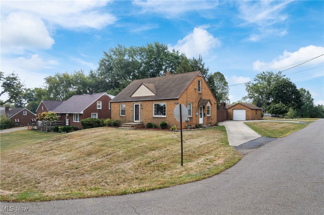 4560 7th Street Northwest Canton, OH 44708 - Photo 27 of 28 View of front of property featuring an outbuilding, brick siding, a front lawn, driveway, and a chimney