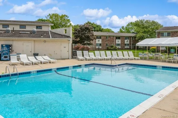 a view of a house with pool and chairs