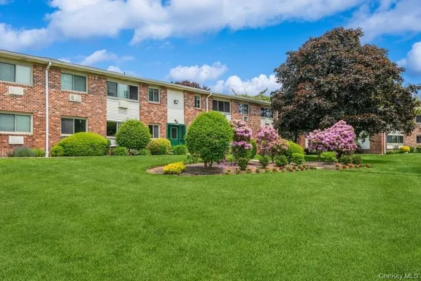 a front view of a house with a garden and plants