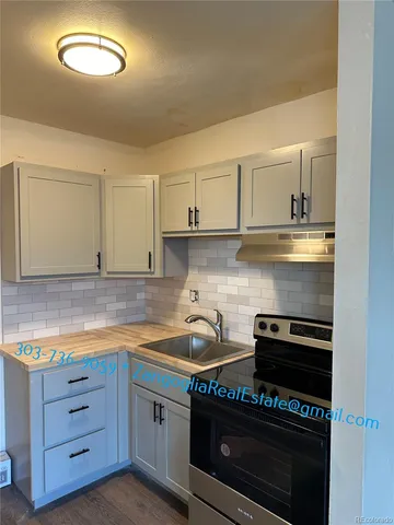 a kitchen with granite countertop a stove and a sink