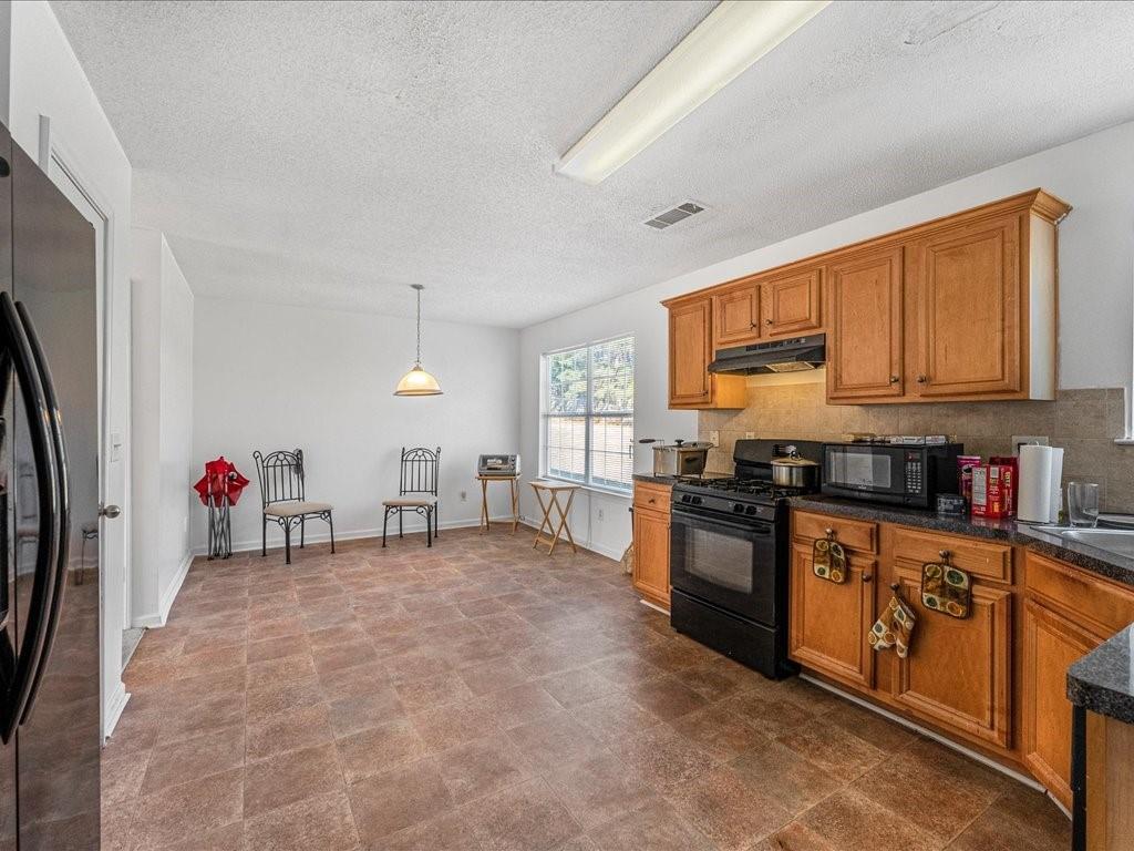 11950 Markham Way Hampton, GA 30228 - Photo 12 of 32 a kitchen with stainless steel appliances granite countertop a stove sink and cabinets