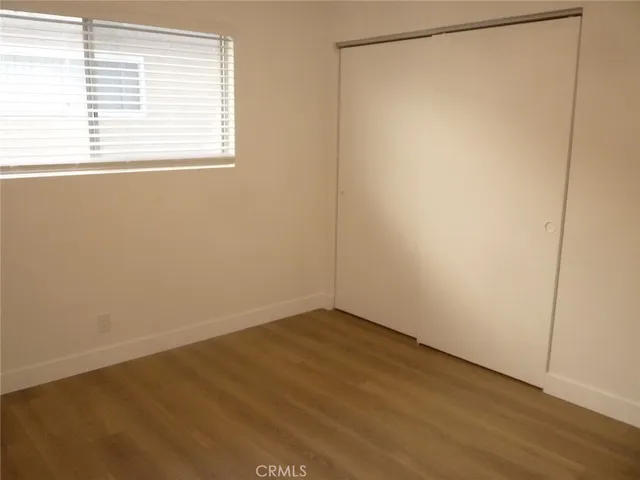 a view of a small space with wooden floor and a window