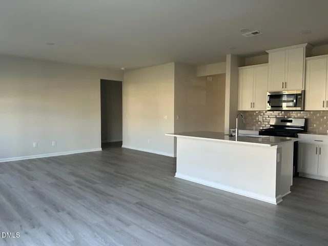 a kitchen with wooden floors and white appliances