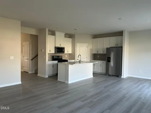 a view of kitchen with stainless steel appliances refrigerator stove microwave and cabinets