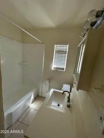 a bathroom with a granite countertop sink a toilet and shower