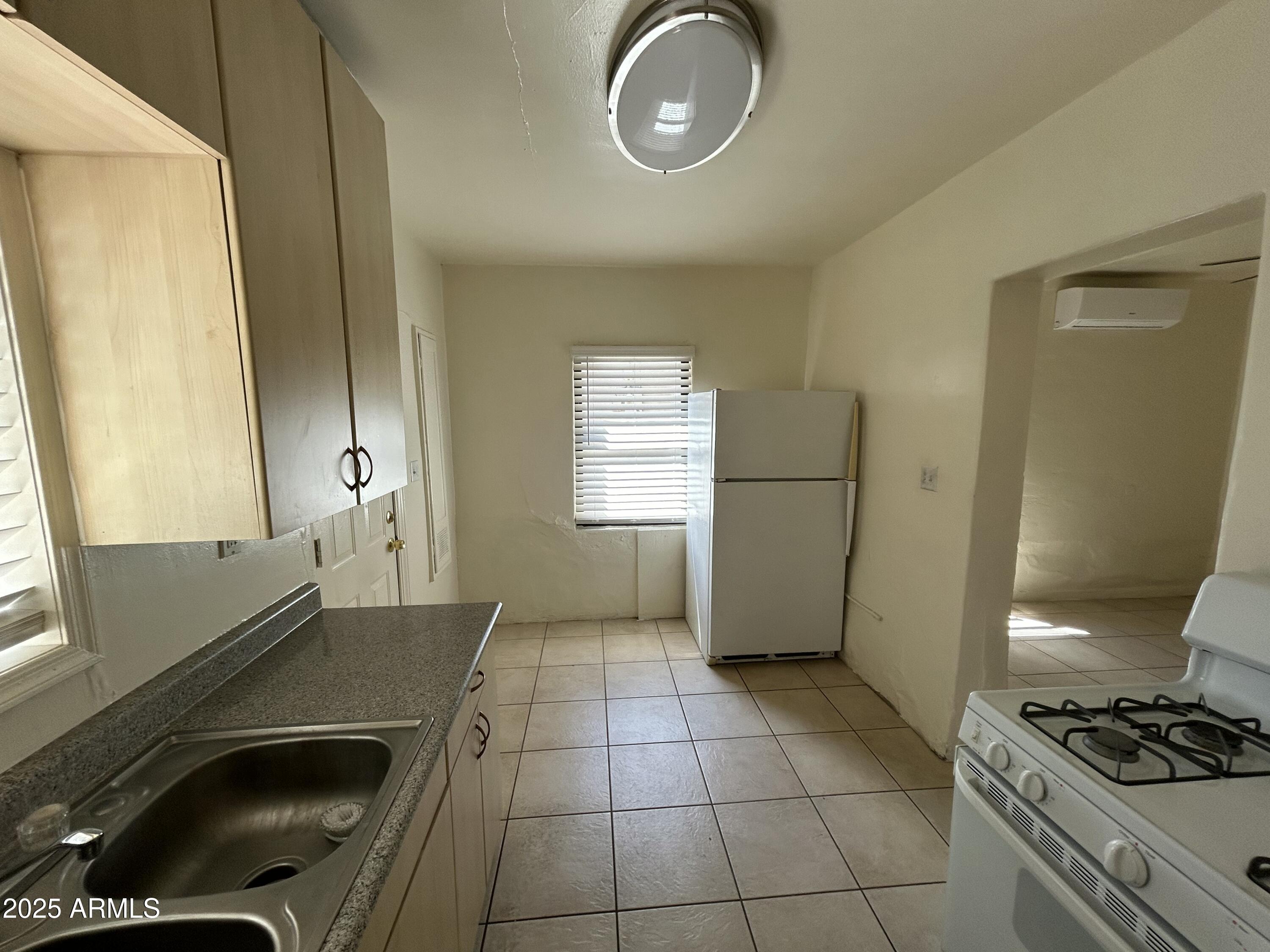 2620 North Stone Avenue Tucson, AZ 85705 - Photo 9 of 12 a kitchen with a refrigerator a stove a sink and a window