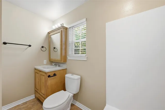 a bathroom with a toilet a sink and mirror