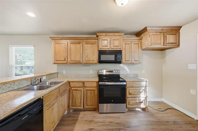 a kitchen with stainless steel appliances granite countertop a sink stove and microwave