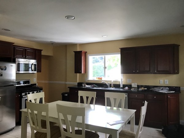 2 Jackson Road Medford, MA 02155 - Photo 7 of 23 a kitchen with stainless steel appliances granite countertop a sink a stove a table and chairs