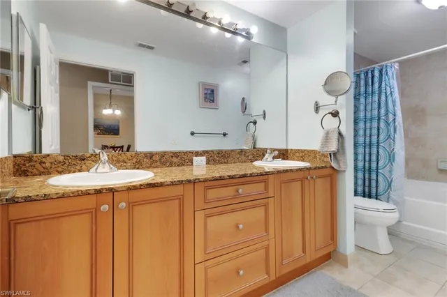 a bathroom with a granite countertop sink a toilet and a mirror