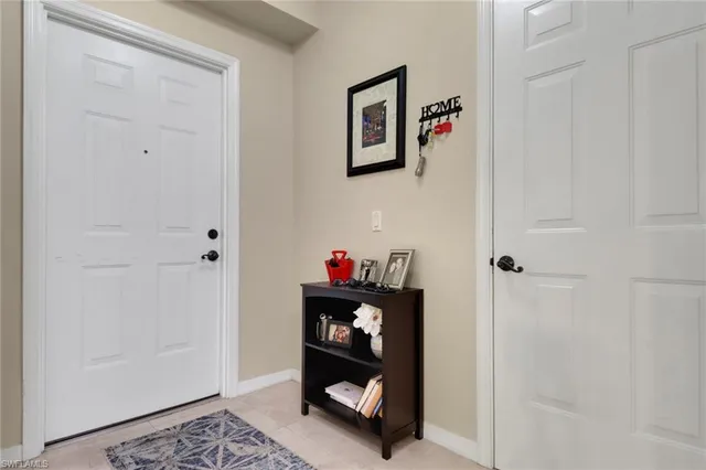 a view of a hallway to room with wooden floor and closet
