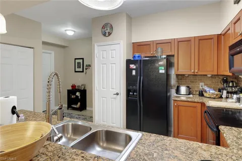 a kitchen with stainless steel appliances granite countertop a refrigerator and a sink