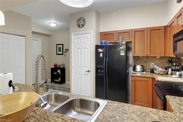 a kitchen with stainless steel appliances granite countertop a refrigerator and a sink